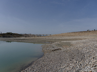 Visible banks, dry soil, and uncultivated vegetation replace the water at Lake Monte Cotugno, a reservoir in Basilicata, which in the summer...