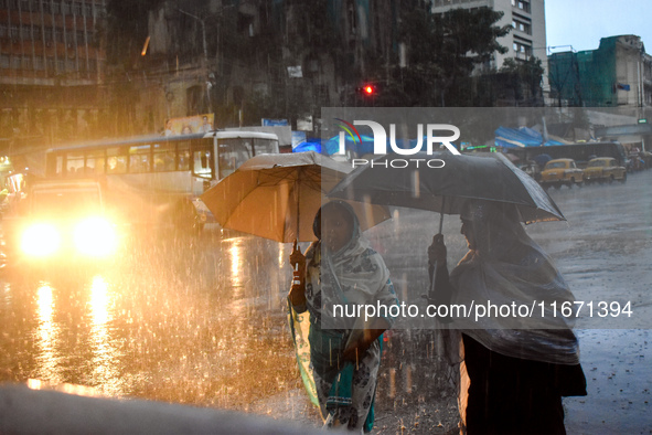 Women hold umbrellas as they walk on the street during heavy rain in Kolkata, India, on October 16, 2024. 