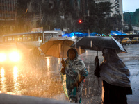 Women hold umbrellas as they walk on the street during heavy rain in Kolkata, India, on October 16, 2024. (