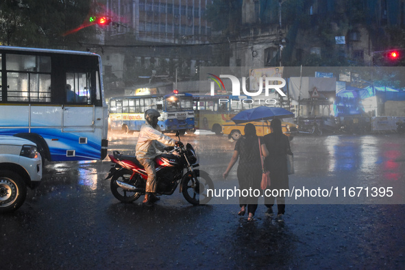 Women hold umbrellas as they walk on the street during heavy rain in Kolkata, India, on October 16, 2024. 