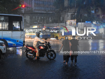 Women hold umbrellas as they walk on the street during heavy rain in Kolkata, India, on October 16, 2024. (