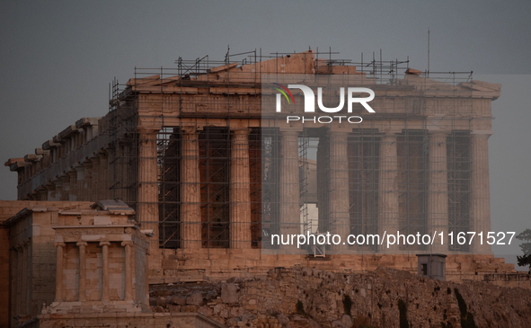 The 'Hunter's supermoon' rises above the Greek Parthenon Temple (438 BC), covered by scaffolding, at the Acropolis archaeological site in At...