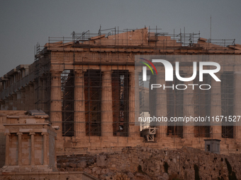 The 'Hunter's supermoon' rises above the Greek Parthenon Temple (438 BC), covered by scaffolding, at the Acropolis archaeological site in At...