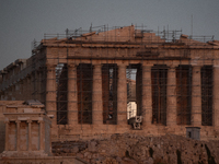 The 'Hunter's supermoon' rises above the Greek Parthenon Temple (438 BC), covered by scaffolding, at the Acropolis archaeological site in At...