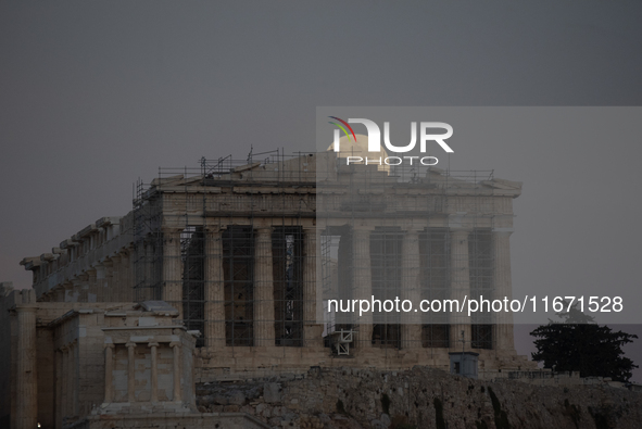 The 'Hunter's supermoon' rises above the Greek Parthenon Temple (438 BC), covered by scaffolding, at the Acropolis archaeological site in At...