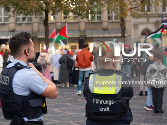 Police observe the demonstration site as dozens of pro-Palestinian activists gather at Muenster Square and protest against deadly Israeli ai...