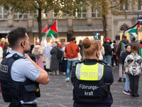 Police observe the demonstration site as dozens of pro-Palestinian activists gather at Muenster Square and protest against deadly Israeli ai...