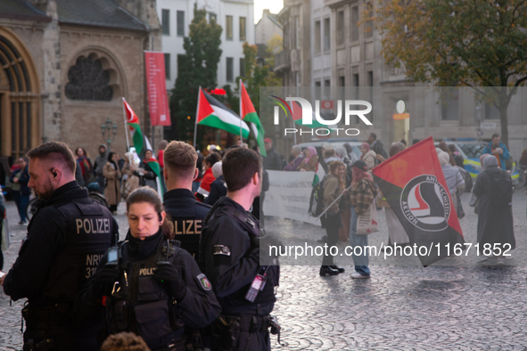 Police observe the demonstration site as dozens of pro-Palestinian activists gather at Muenster Square and protest against deadly Israeli ai...