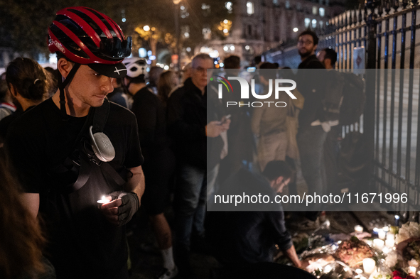 This photograph shows bunches of mainly white flowers displayed with candles as cyclists pay tribute to Paul, 27, a cyclist who was run over...