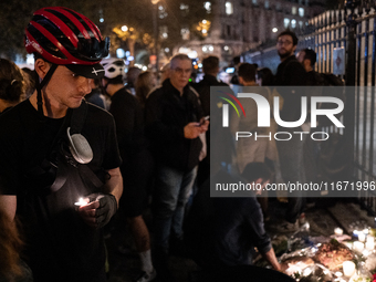 This photograph shows bunches of mainly white flowers displayed with candles as cyclists pay tribute to Paul, 27, a cyclist who was run over...