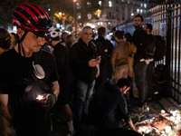 This photograph shows bunches of mainly white flowers displayed with candles as cyclists pay tribute to Paul, 27, a cyclist who was run over...