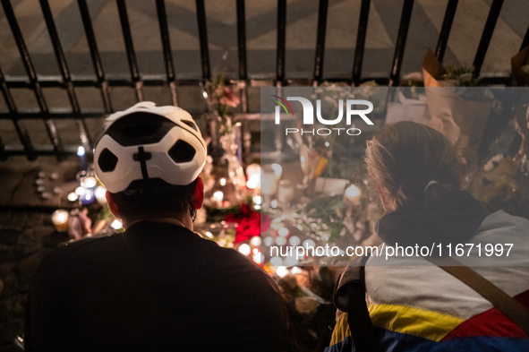 This photograph shows bunches of mainly white flowers displayed with candles as cyclists pay tribute to Paul, 27, a cyclist who was run over...