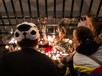 This photograph shows bunches of mainly white flowers displayed with candles as cyclists pay tribute to Paul, 27, a cyclist who was run over...