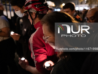 This photograph shows bunches of mainly white flowers displayed with candles as cyclists pay tribute to Paul, 27, a cyclist who was run over...