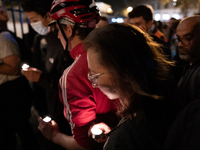 This photograph shows bunches of mainly white flowers displayed with candles as cyclists pay tribute to Paul, 27, a cyclist who was run over...