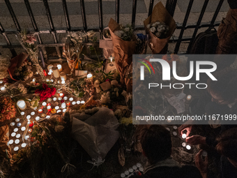 This photograph shows bunches of mainly white flowers displayed with candles as cyclists pay tribute to Paul, 27, a cyclist who was run over...