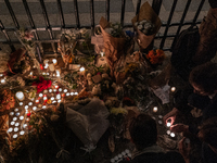 This photograph shows bunches of mainly white flowers displayed with candles as cyclists pay tribute to Paul, 27, a cyclist who was run over...