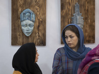 Two Iranian female artists sit at their stand during the 11th National Handicrafts and 3rd International Tourism Exhibition in the historica...