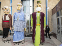 An Iranian man speaks on his cellphone while standing next to effigies during the 11th National Handicrafts and 3rd International Tourism Ex...