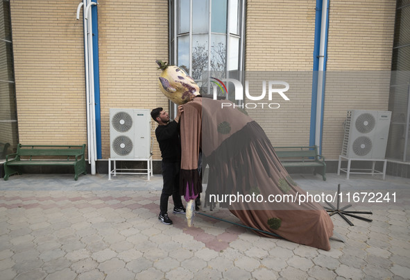 An Iranian man adjusts an effigy during the 11th National Handicrafts and 3rd International Tourism Exhibition in the historical city of Tab...