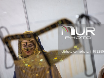 An Iranian woman wears a traditional headscarf and a burqa during the 11th National Handicrafts and 3rd International Tourism Exhibition in...