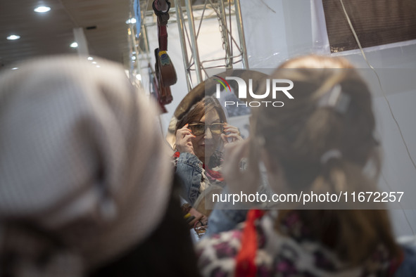 An Iranian woman tries on sunglasses while visiting the 11th National Handicrafts and 3rd International Tourism Exhibition in the historical...