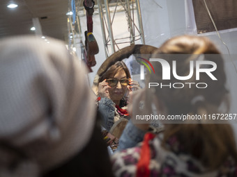 An Iranian woman tries on sunglasses while visiting the 11th National Handicrafts and 3rd International Tourism Exhibition in the historical...