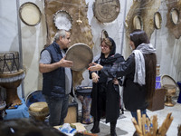 An Iranian trader plays a traditional musical instrument for women visiting the 11th National Handicrafts and 3rd International Tourism Exhi...