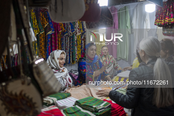 Iranian saleswomen talk to clients during the 11th National Handicrafts and 3rd International Tourism Exhibition in the historical city of T...