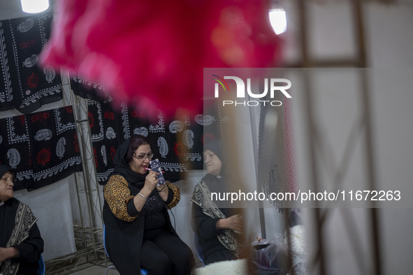 An Iranian female trader applies makeup while sitting at her stand during the 11th National Handicrafts and 3rd International Tourism Exhibi...