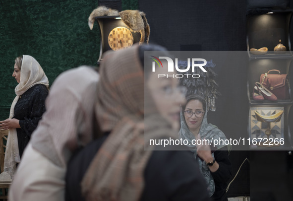 An Iranian female trader smiles while sitting at her stand at the 11th National Handicrafts and 3rd International Tourism Exhibition in Tabr...