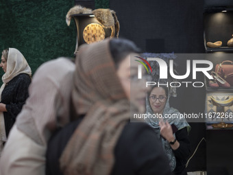 An Iranian female trader smiles while sitting at her stand at the 11th National Handicrafts and 3rd International Tourism Exhibition in Tabr...