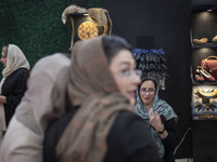 An Iranian female trader smiles while sitting at her stand at the 11th National Handicrafts and 3rd International Tourism Exhibition in Tabr...