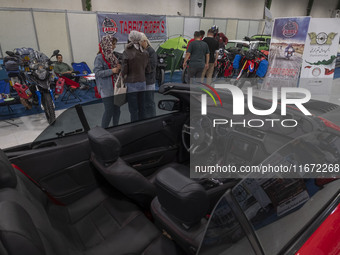 Iranian women stand together next to a vehicle while visiting the 11th National Handicrafts and 3rd International Tourism Exhibition in the...