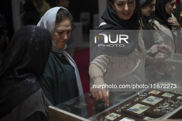 An Iranian woman points at jewelry while visiting the 11th National Handicrafts and 3rd International Tourism Exhibition in the historical c...