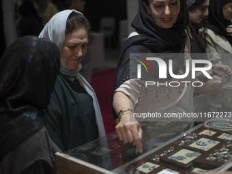 An Iranian woman points at jewelry while visiting the 11th National Handicrafts and 3rd International Tourism Exhibition in the historical c...