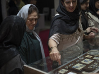 An Iranian woman points at jewelry while visiting the 11th National Handicrafts and 3rd International Tourism Exhibition in the historical c...