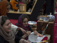 An Iranian female artist works at a stand during the 11th National Handicrafts and 3rd International Tourism Exhibition in the historical ci...