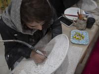 An Iranian female artist works at a stand during the 11th National Handicrafts and 3rd International Tourism Exhibition in the historical ci...