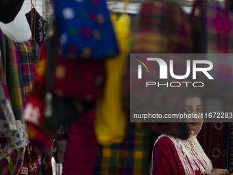 An Iranian saleswoman stands at her stand during the 11th National Handicrafts and 3rd International Tourism Exhibition in Tabriz, Iran, on...