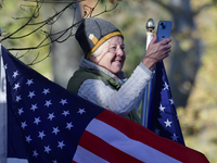 A supporter stands between American flags as U.S. Vice President Kamala Harris greets supporters after a campaign event with a group of curr...