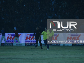 A cricket fan is tackled by security personnel following a pitch invasion during the finals of the Legends League Cricket T20 match between...