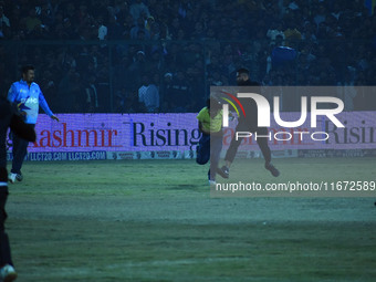 A cricket fan is tackled by security personnel following a pitch invasion during the finals of the Legends League Cricket T20 match between...