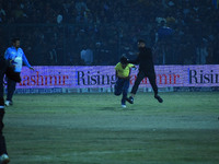 A cricket fan is tackled by security personnel following a pitch invasion during the finals of the Legends League Cricket T20 match between...