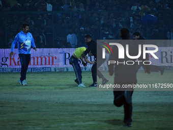 A cricket fan is tackled by security personnel following a pitch invasion during the finals of the Legends League Cricket T20 match between...