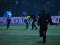 A cricket fan is tackled by security personnel following a pitch invasion during the finals of the Legends League Cricket T20 match between...