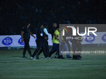 A cricket fan is tackled by security personnel following a pitch invasion during the finals of the Legends League Cricket T20 match between...