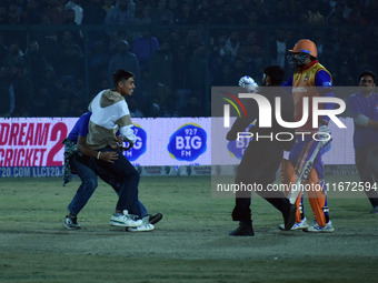 A cricket fan is tackled by security personnel following a pitch invasion during the finals of the Legends League Cricket T20 match between...