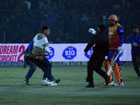 A cricket fan is tackled by security personnel following a pitch invasion during the finals of the Legends League Cricket T20 match between...