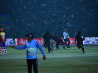 Cricket fans are tackled by security men following a pitch invasion during the finals of the Legends League Cricket T20 match between Southe...